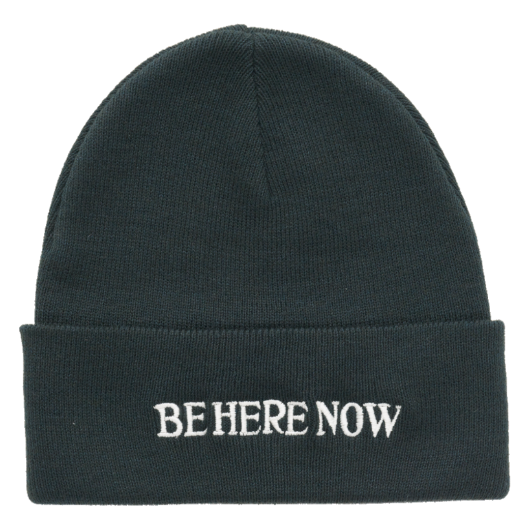 Black beanie with 'BE HERE NOW' text on a white background