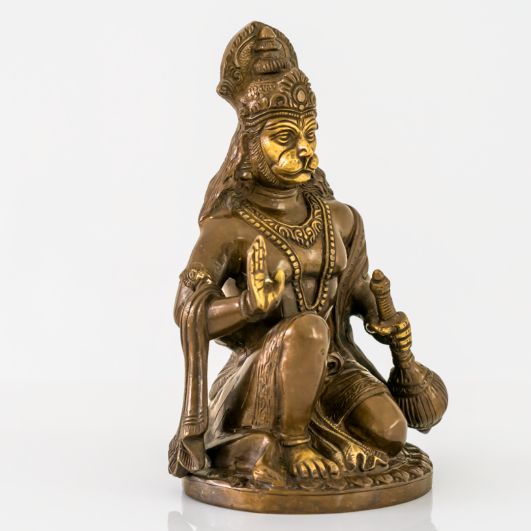 A bronze-finished statue of Lord Hanuman in a seated pose, featuring gold-plated accents on the face, chest, and jewelry, set against a plain white background.