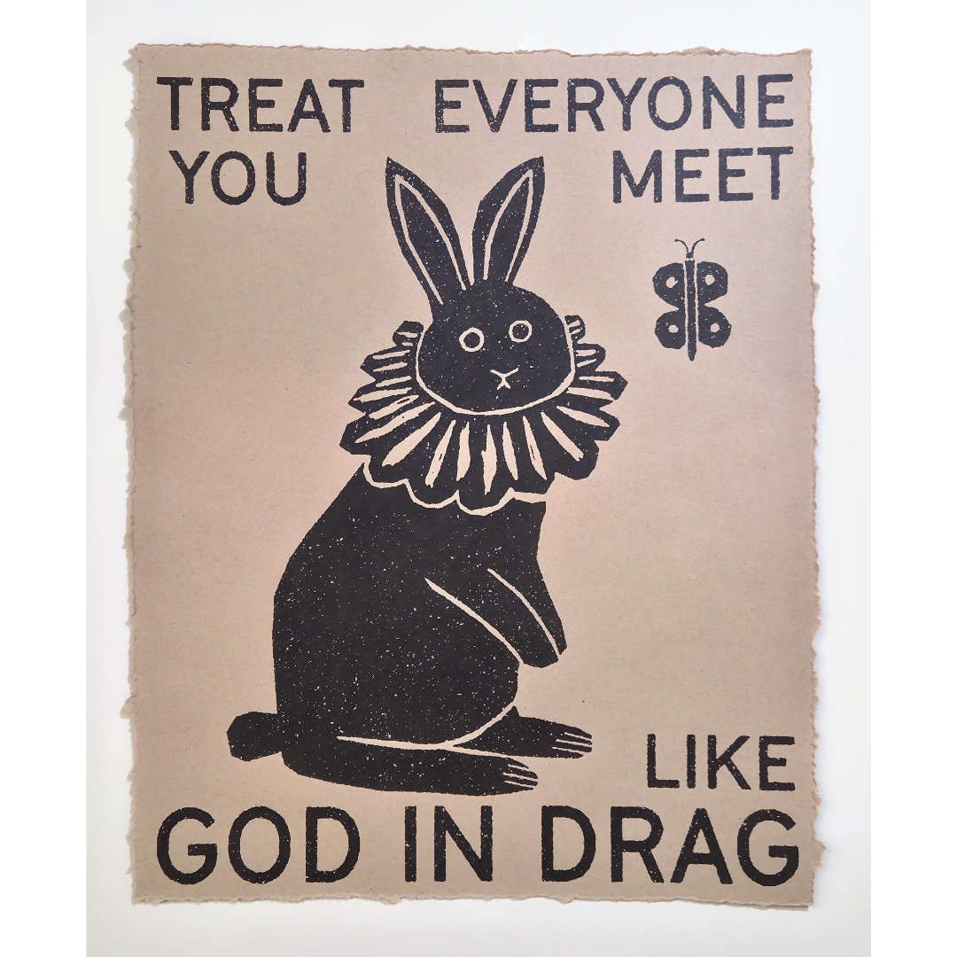 God in Drag poster print featuring a black rabbit wearing a ruffled collar beside a butterfly, with text reading "Treat everyone you meet like God in drag"