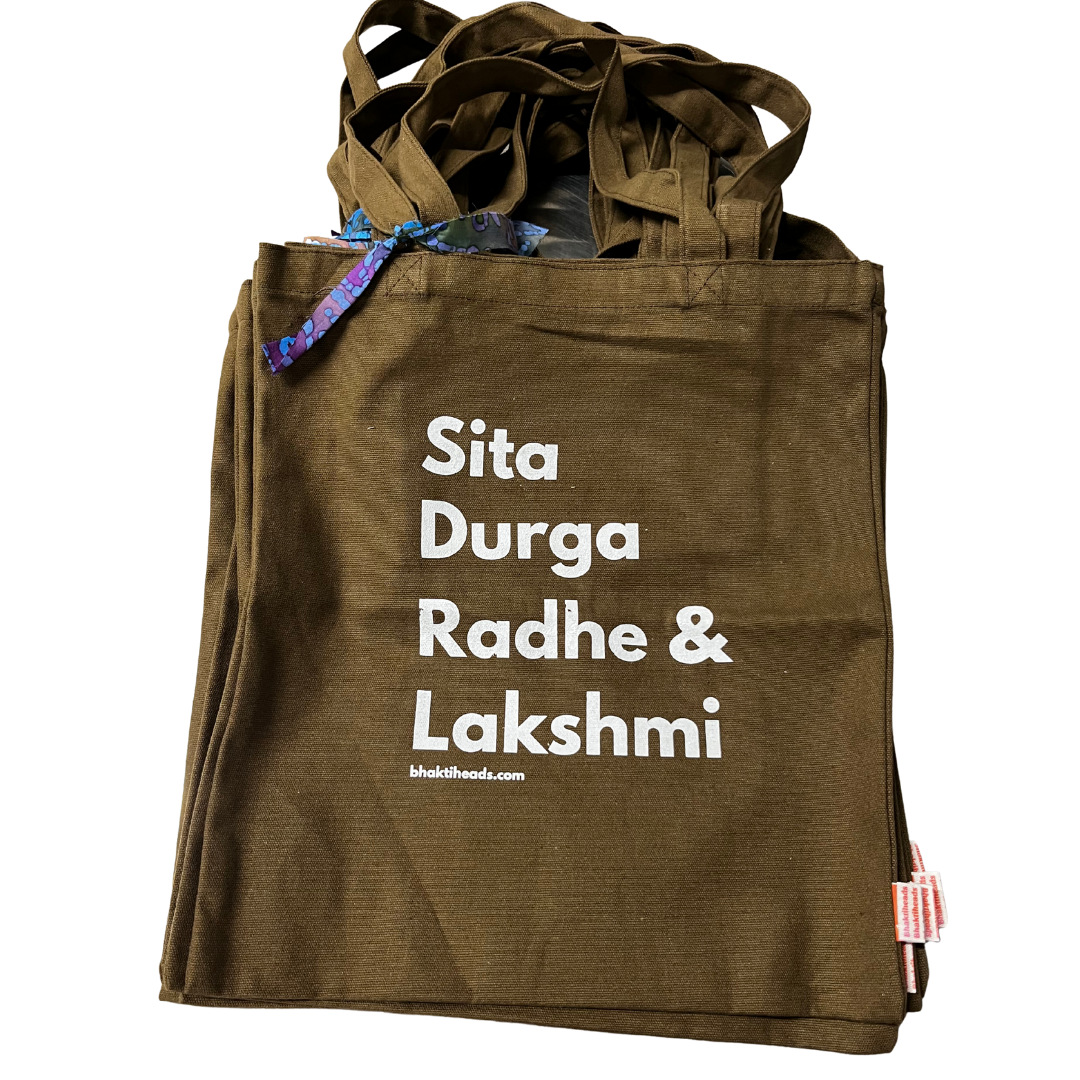 An olive brown canvas tote bag with white printed text reading 'Sita Durga Radhe &amp; Lakshmi' and a small 'mukitlhoods.com' URL.