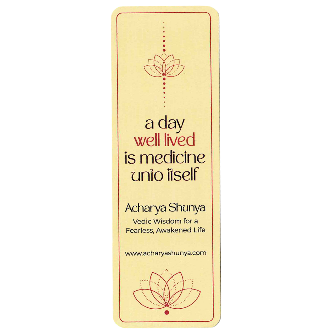 A vertical cream-colored book bookmark featuring a red lotus design and the quote 'a day well lived is medicine unto itself' by Acharya Shunya, shown on a plain white background.