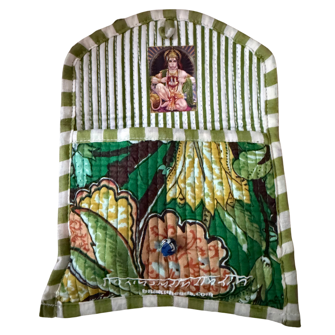 A quilted fabric pouch or pocket with a green and white striped top border and a colorful floral print lower section. A small printed religious image of a seated figure is stitched near the top center, and a small blue bead hangs from the front.